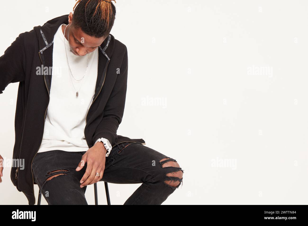 Fashionable man sitting and looking down Stock Photo