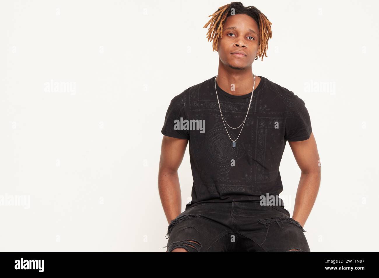 Young man with dreadlocks posing in black attire Stock Photo