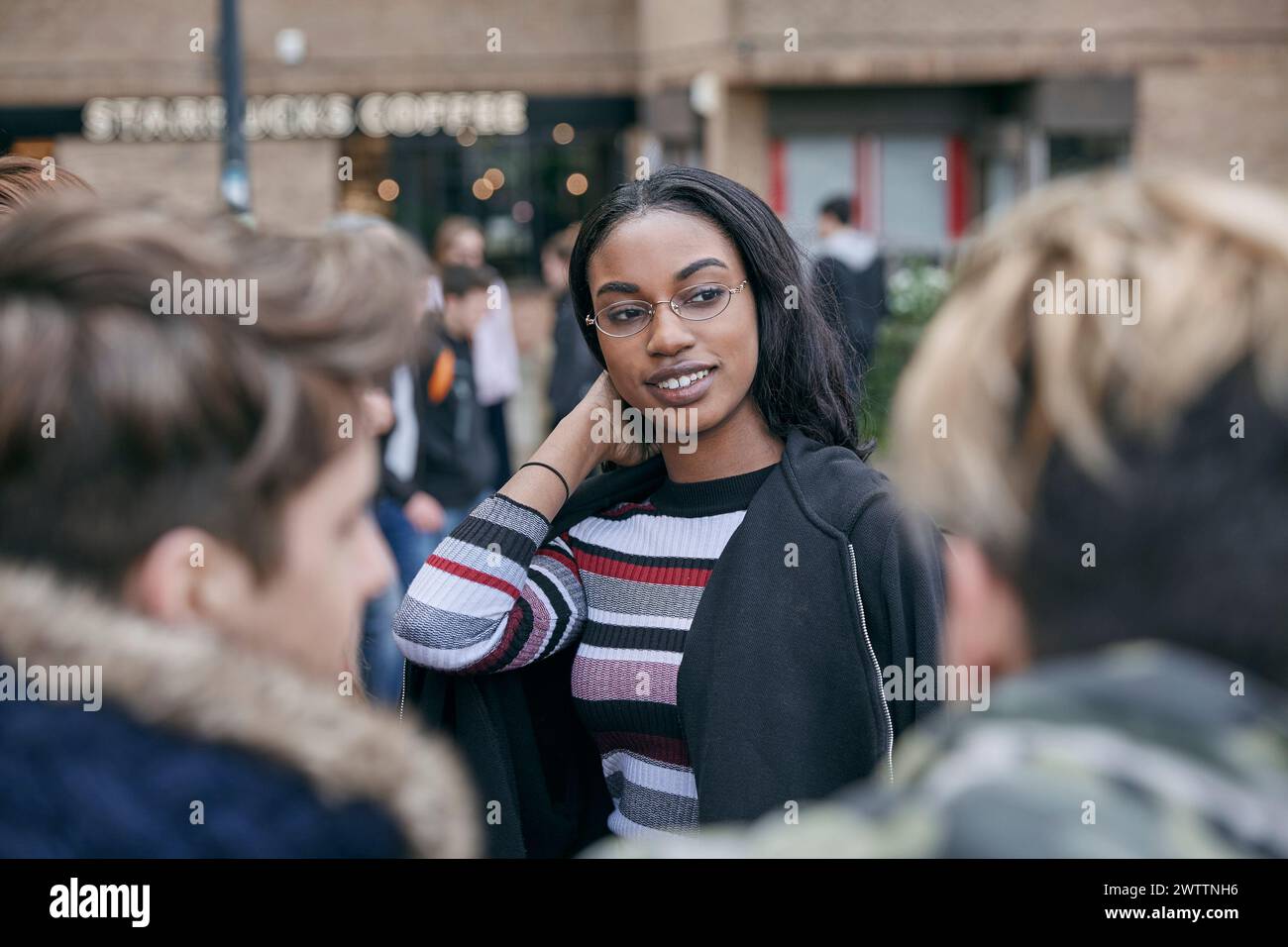 Woman smiling among friends outdoors Stock Photo