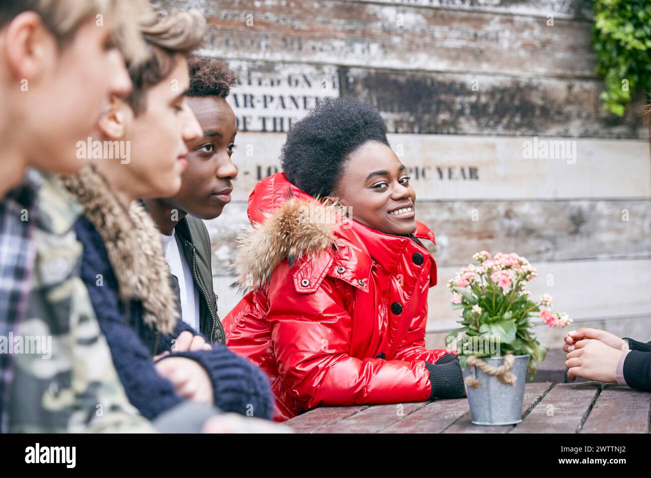 Friends gathered around a table smiling Stock Photo