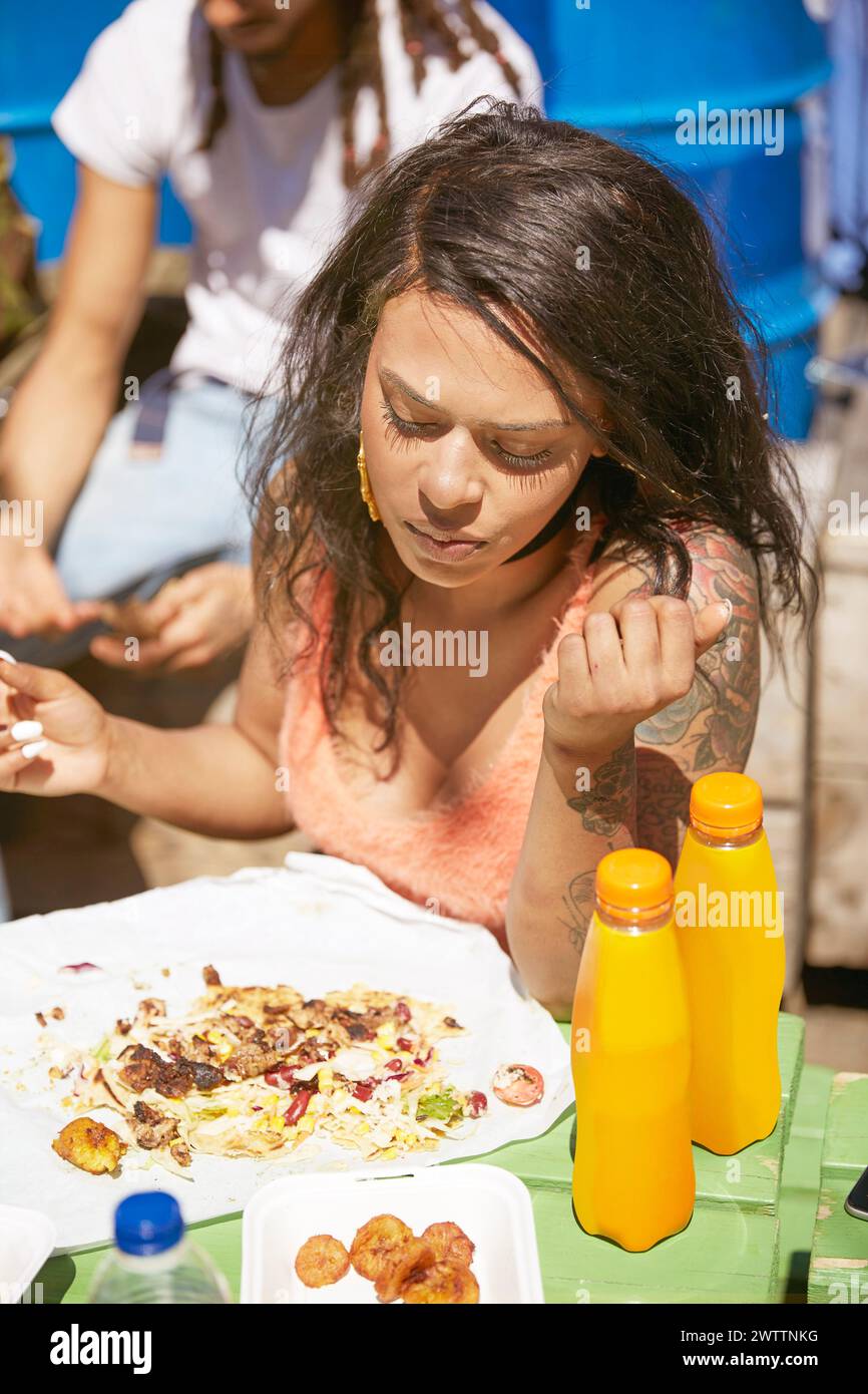 Woman eating at an outdoor table Stock Photo