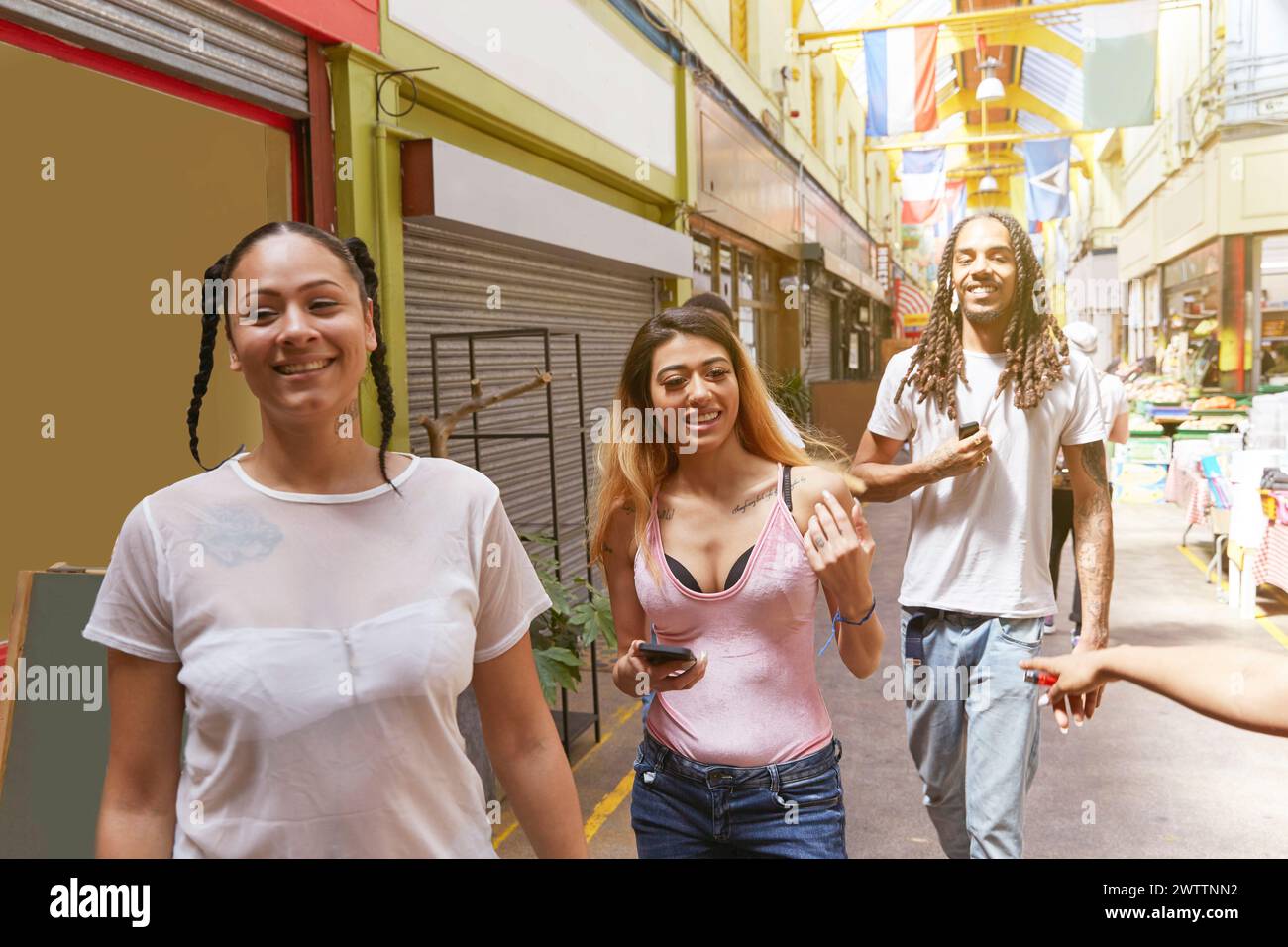 Three friends walking and laughing together in an alley Stock Photo