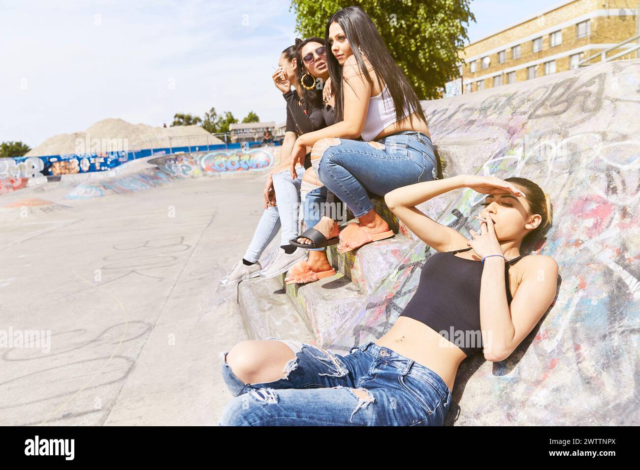 Friends hanging out at a graffiti-covered skatepark Stock Photo