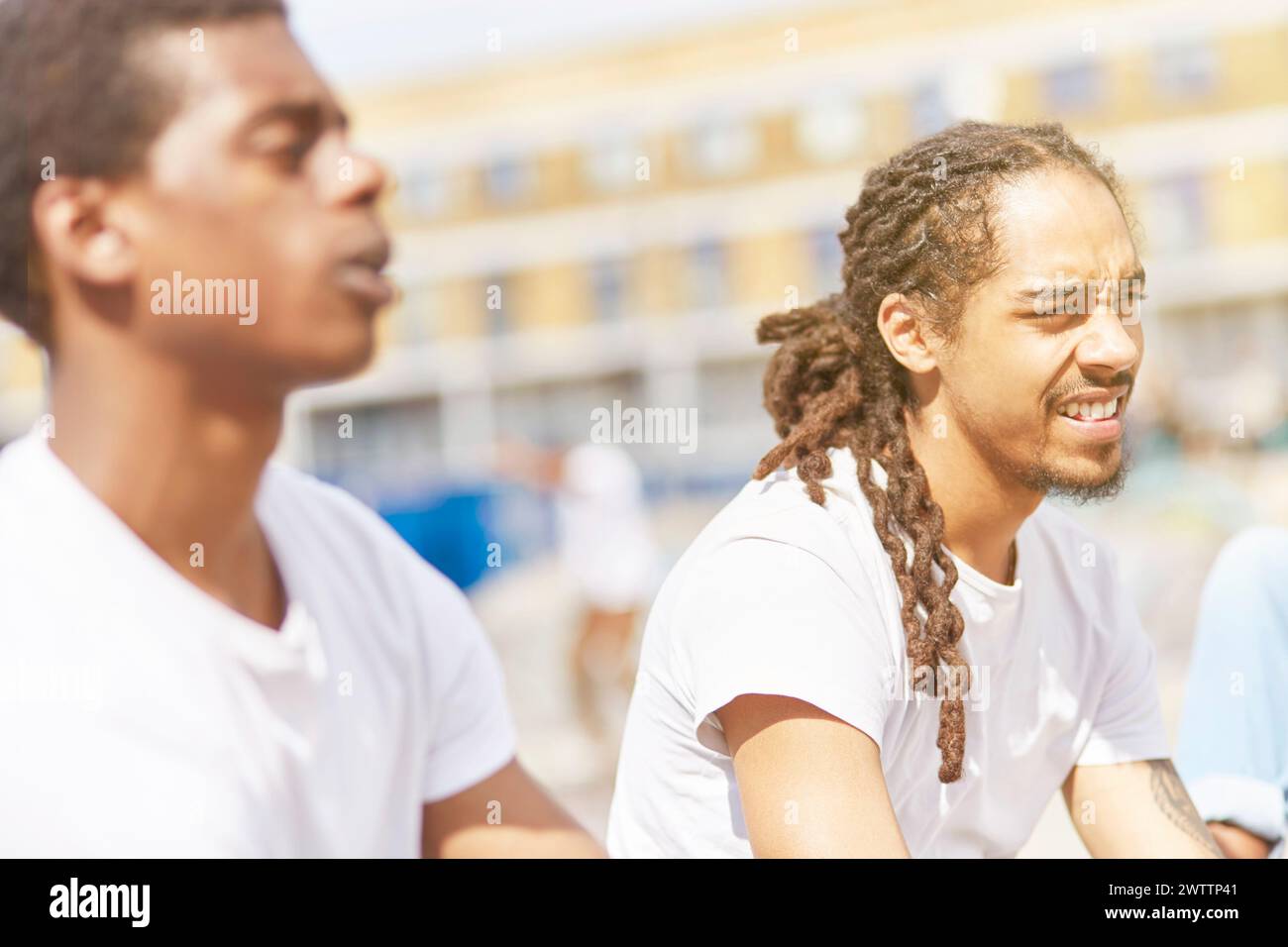 Two individuals outdoors squinting in sunlight Stock Photo