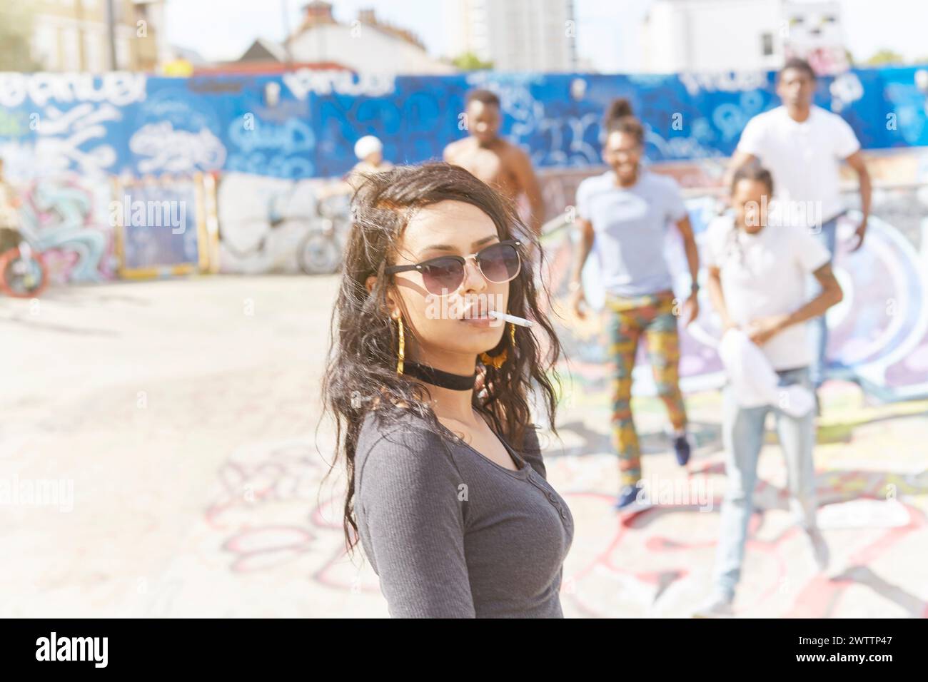 Young woman in focus with friends at a graffiti wall Stock Photo - Alamy