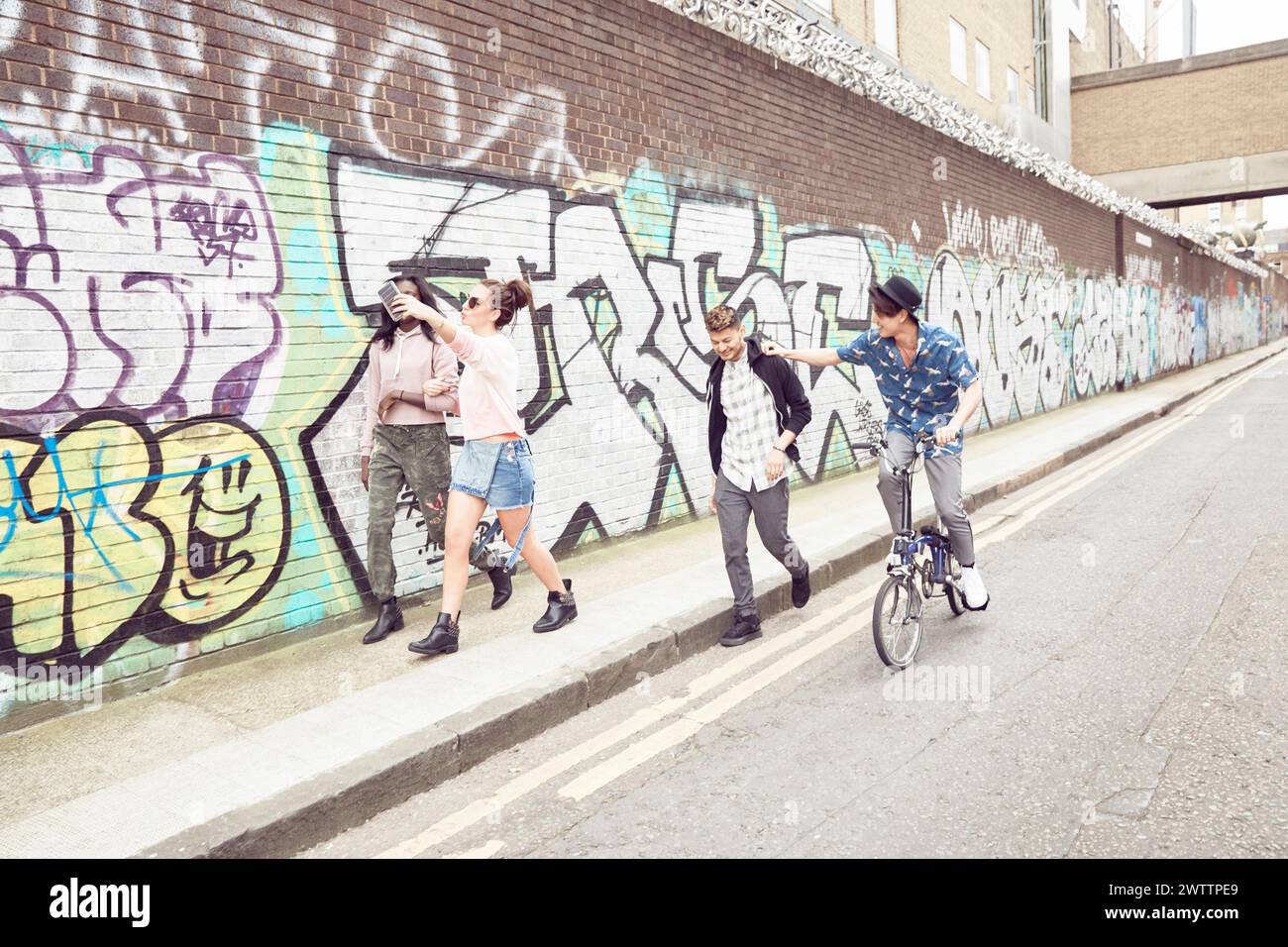 Group of friends having fun near a graffiti wall Stock Photo