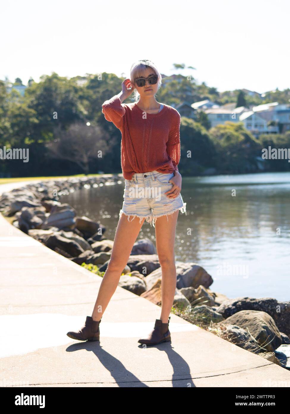 Woman posing by a lakeside path Stock Photo