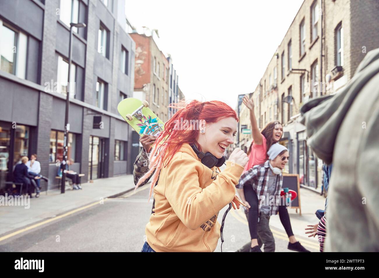 Group of friends enjoying a playful moment on a city street Stock Photo
