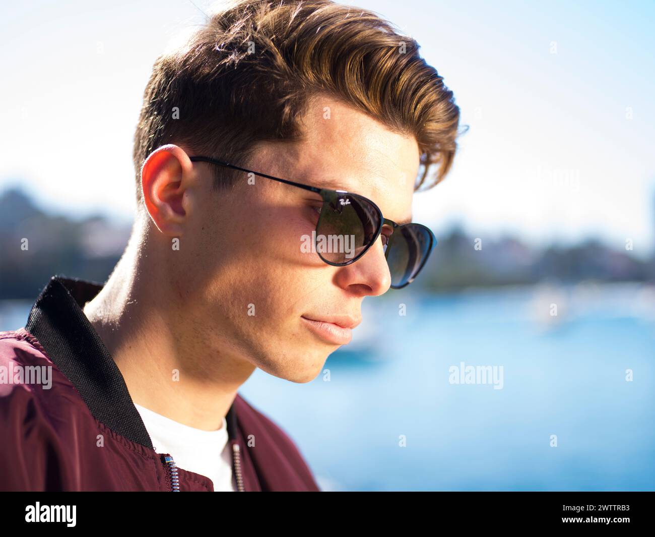 Young man wearing sunglasses by the water. Stock Photo