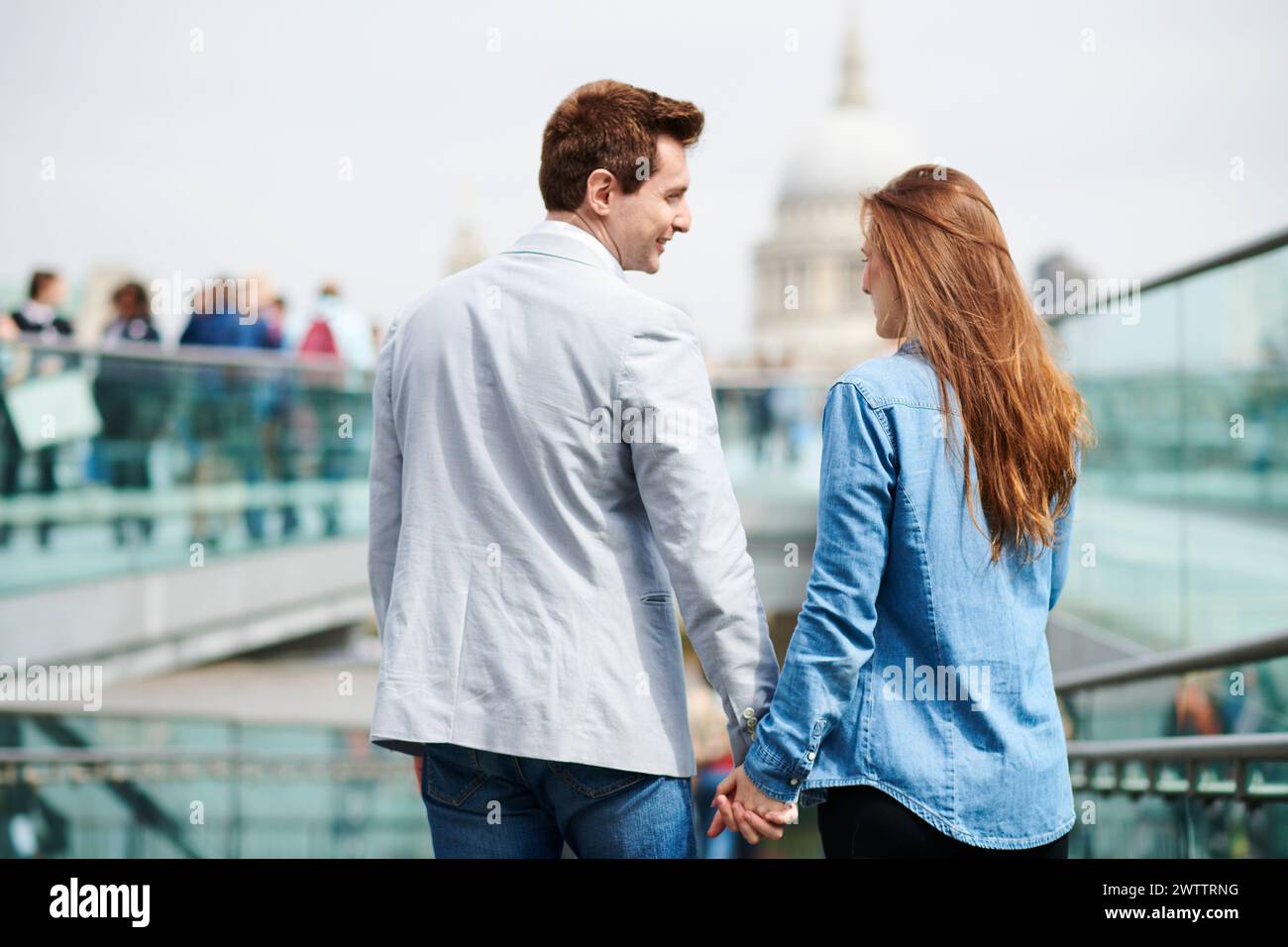 Couple holding hands on a city bridge Stock Photo