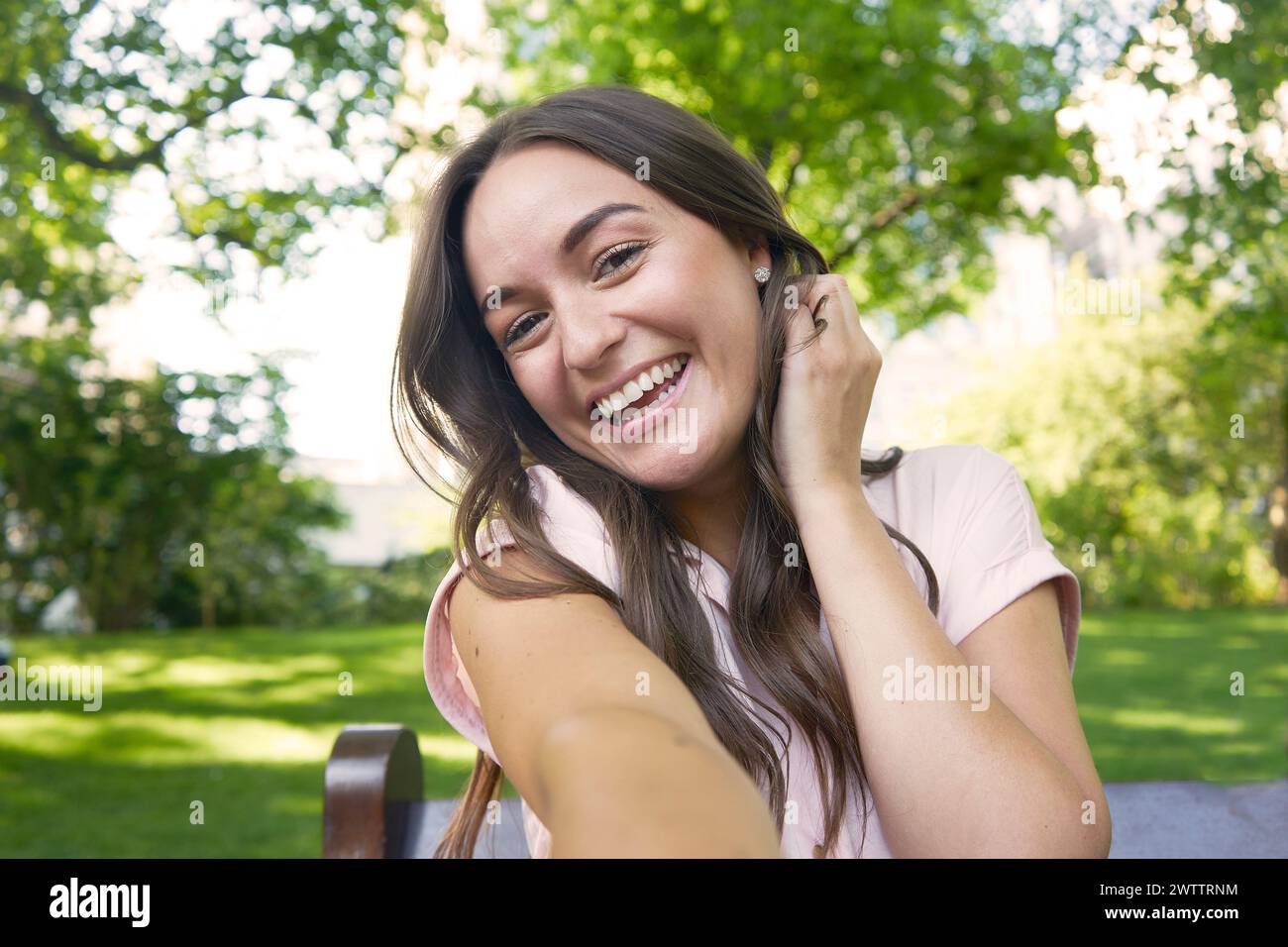 Smiling woman sitting outdoors Stock Photo