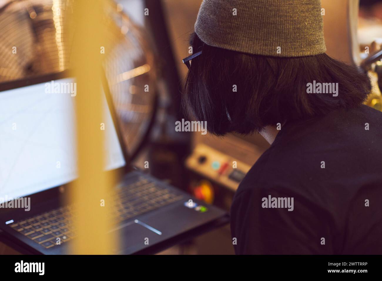 Person working on a laptop with graphs on the screen Stock Photo