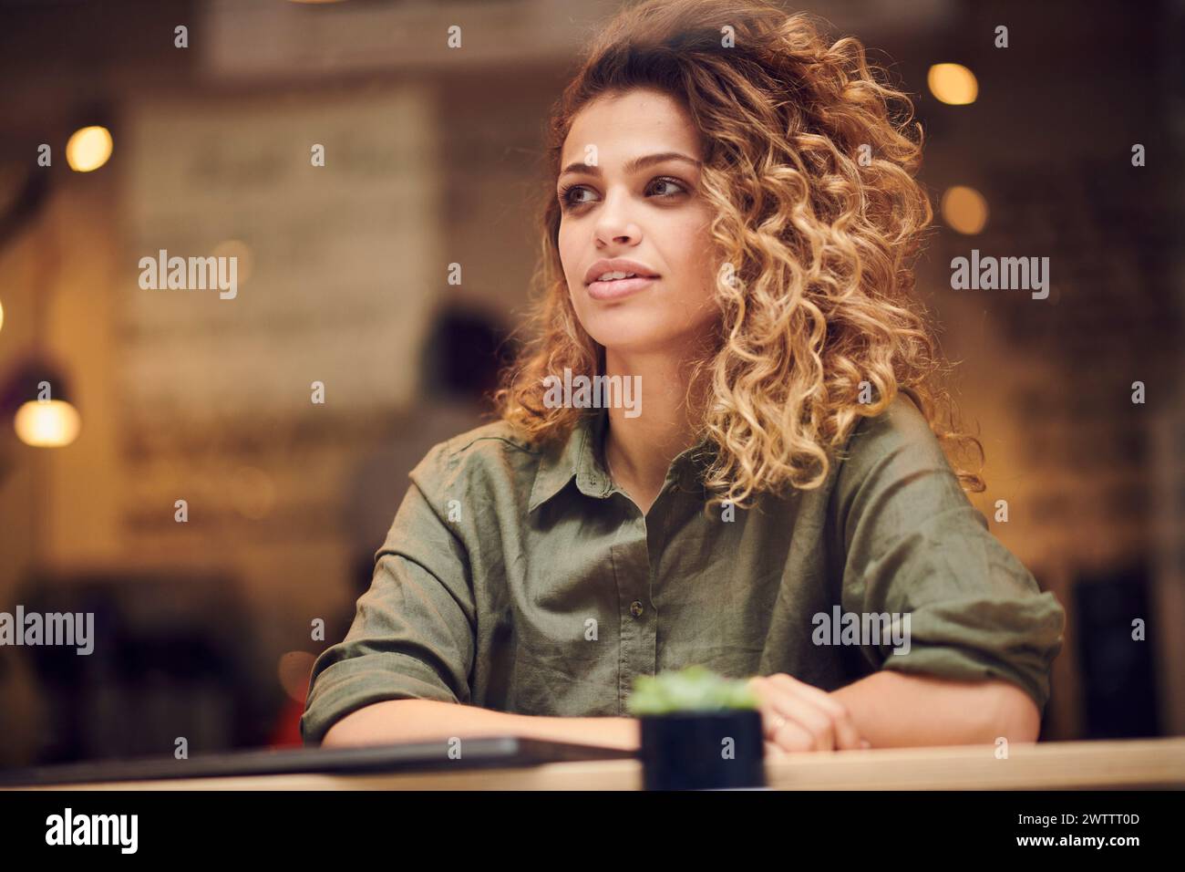 Woman with curly hair sitting in a cafe Stock Photo