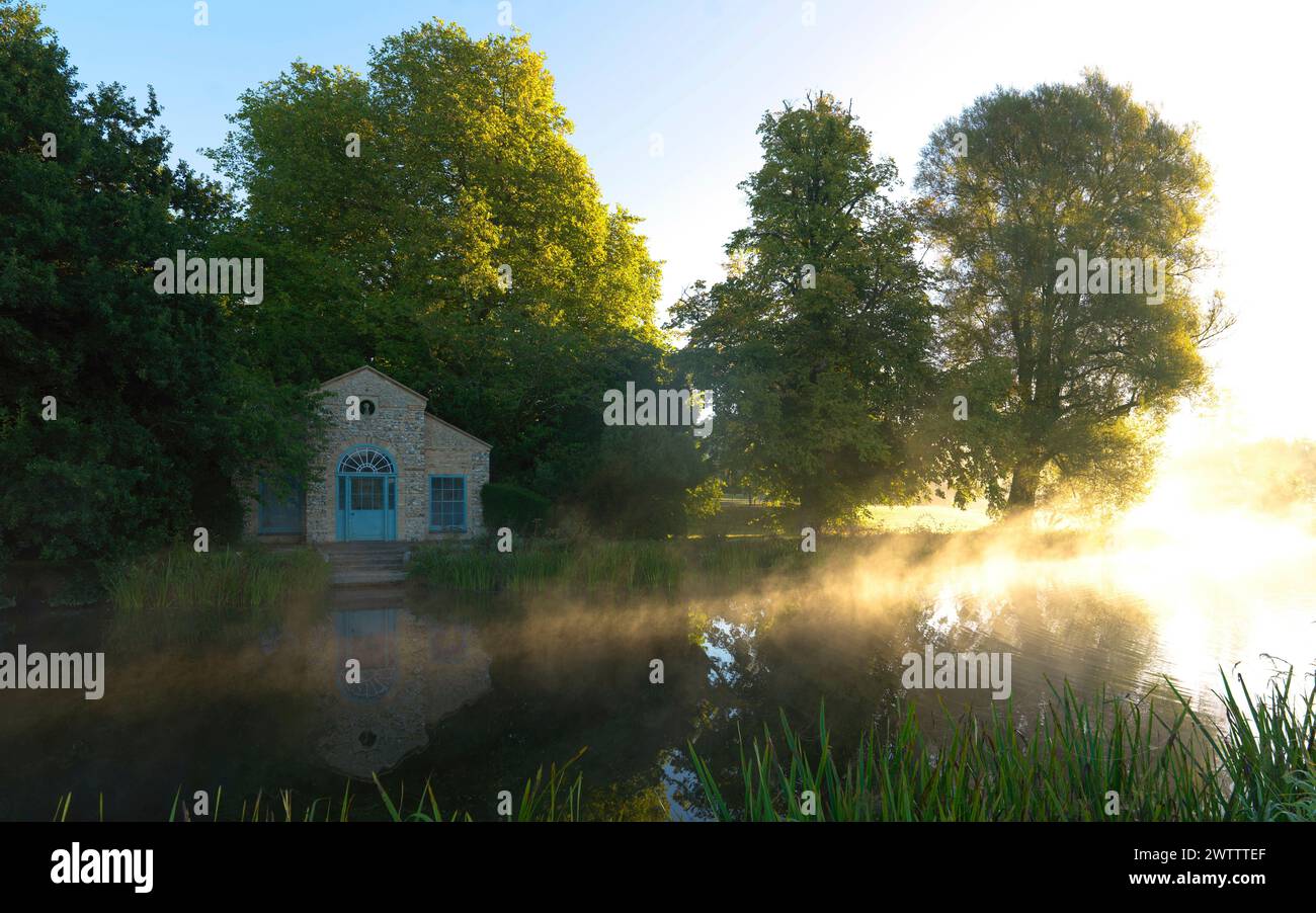 Sunrise over a tranquil lake with a small house Stock Photo