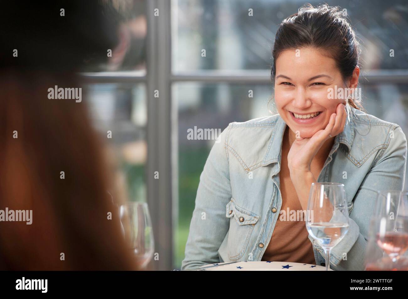 Woman smiling at a dining table. Stock Photo