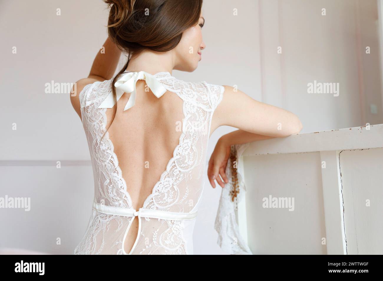 Woman in a lace bridal gown looking away Stock Photo