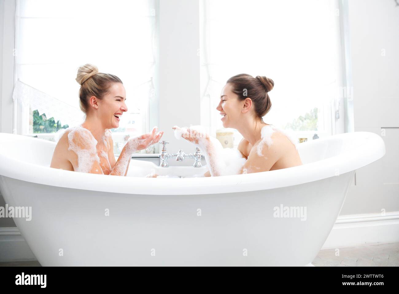 Two women laughing in a bubble bath Stock Photo