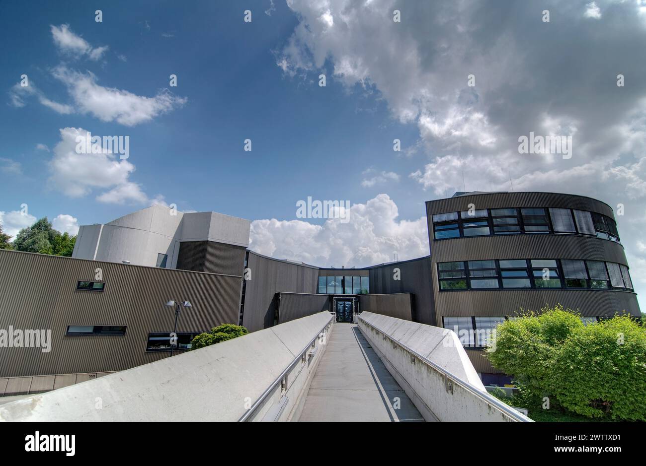 Modern building with a ramp entrance under a cloudy sky Stock Photo