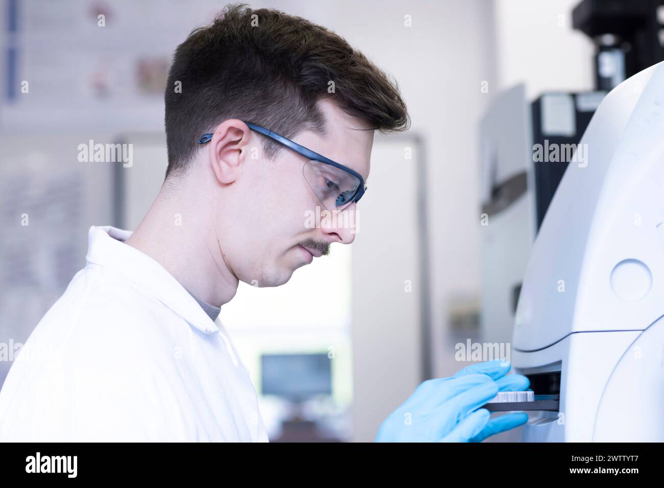 Young scientist analyzing samples in a laboratory setting. Stock Photo