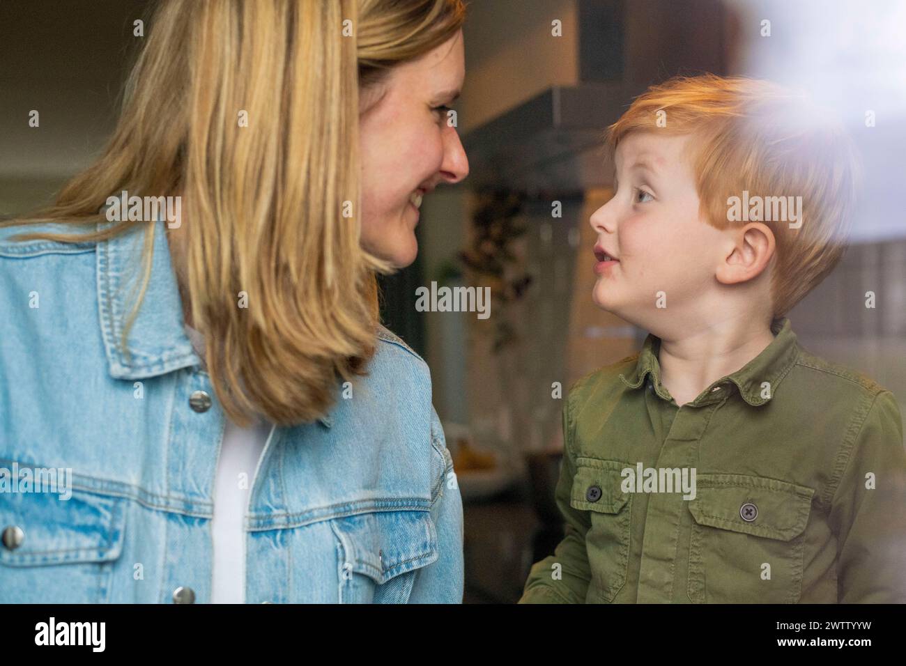 Heartwarming moment as a young boy gazes at his mother with love and curiosity. Stock Photo