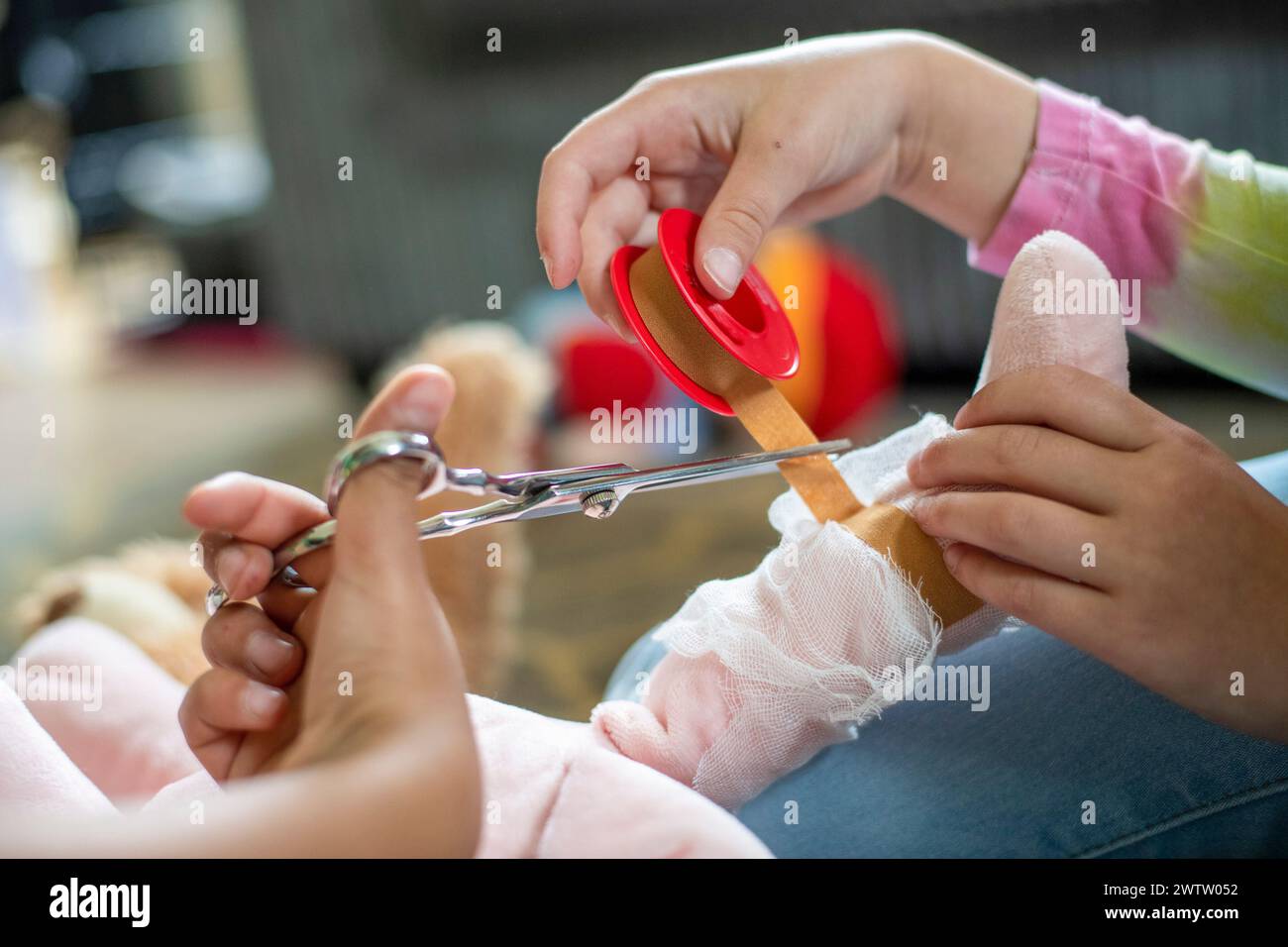 Gentle hands carefully cutting a bandage from a healing wound Stock Photo