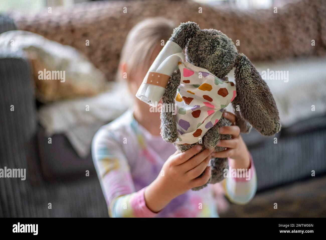 Child having a playful moment with a stuffed animal. Stock Photo