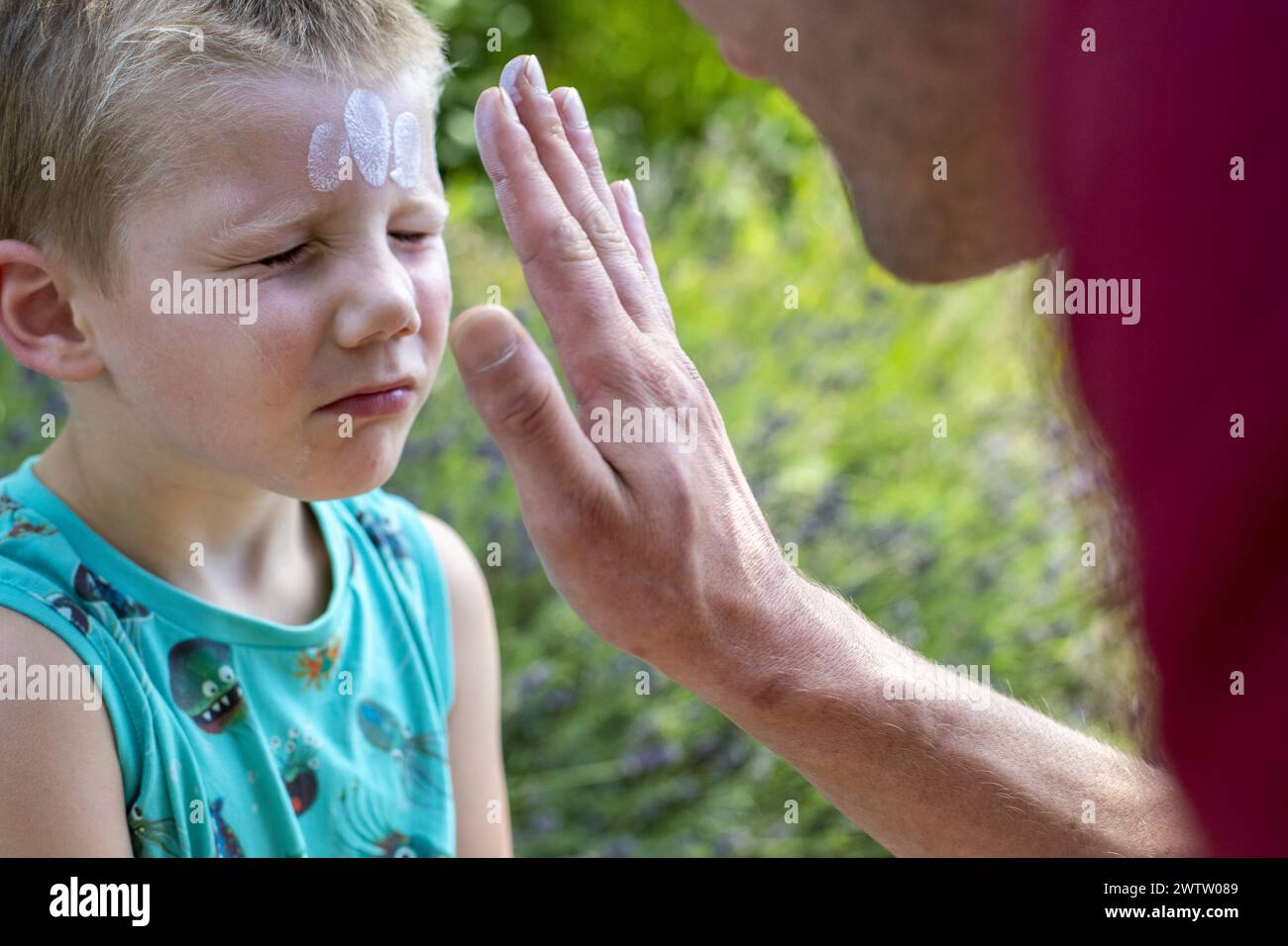 Child receiving face paint outdoors Stock Photo