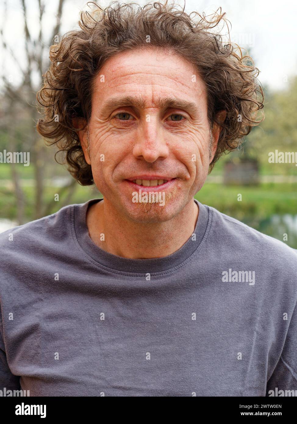Man with curly hair outdoors Stock Photo