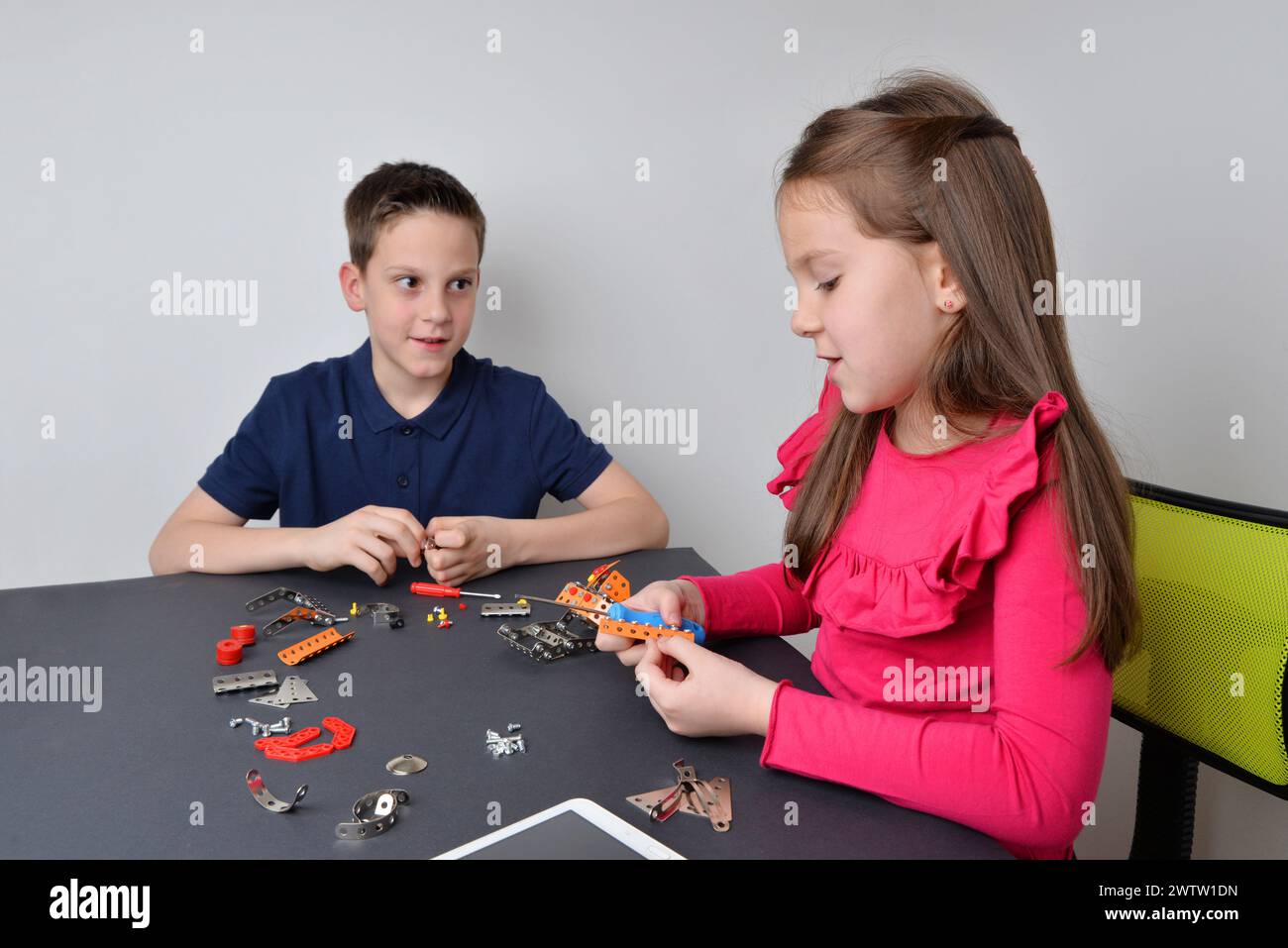 Boy and girl work together on a robot project, intertwining learning with social interaction Stock Photo