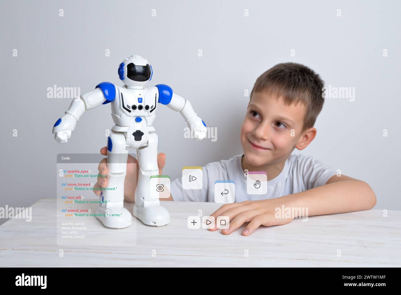 Boy is holding a robot in his hand with conceptual robot programming ...
