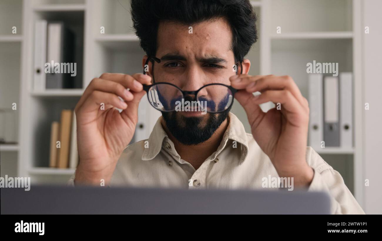 Unhealthy Indian Arabian man in glasses for laptop business work