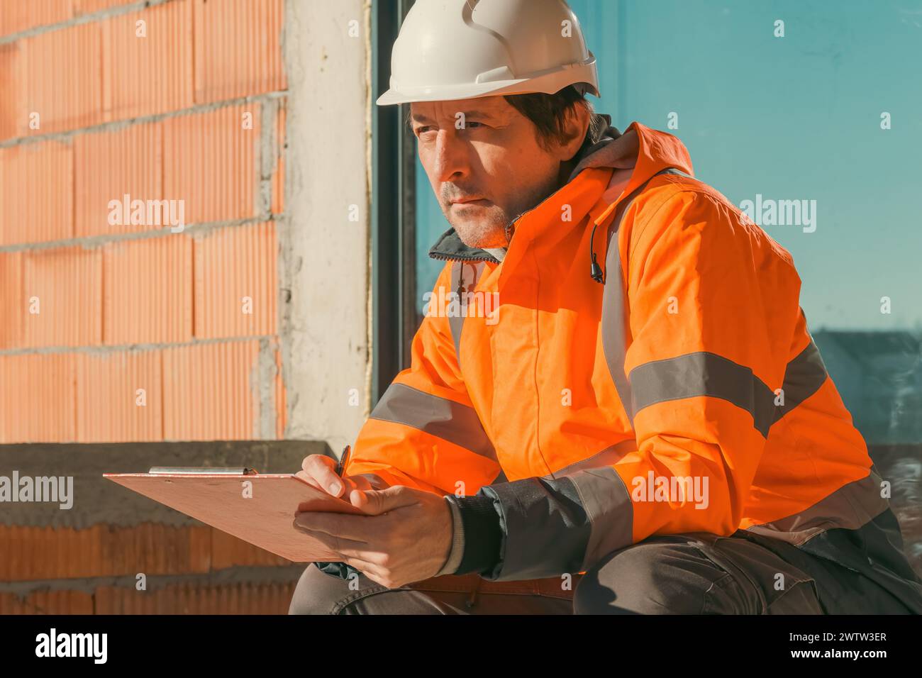 Building contractor and construction engineer making sketches and writing notes on building site, selective focus Stock Photo