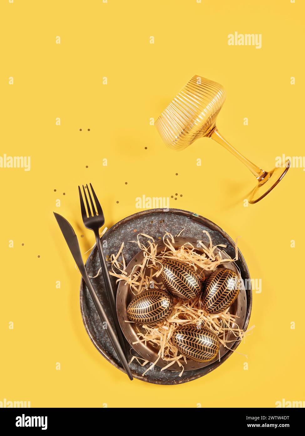 Table place setting and festive easter decor on yellow background Stock Photo