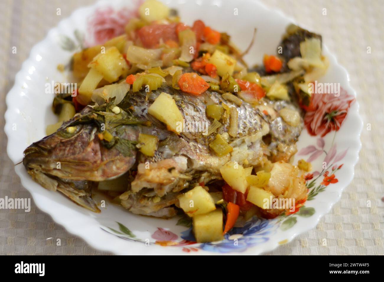 Baked tilapia fish Oreochromis niloticus mixed with slices of tomatoes