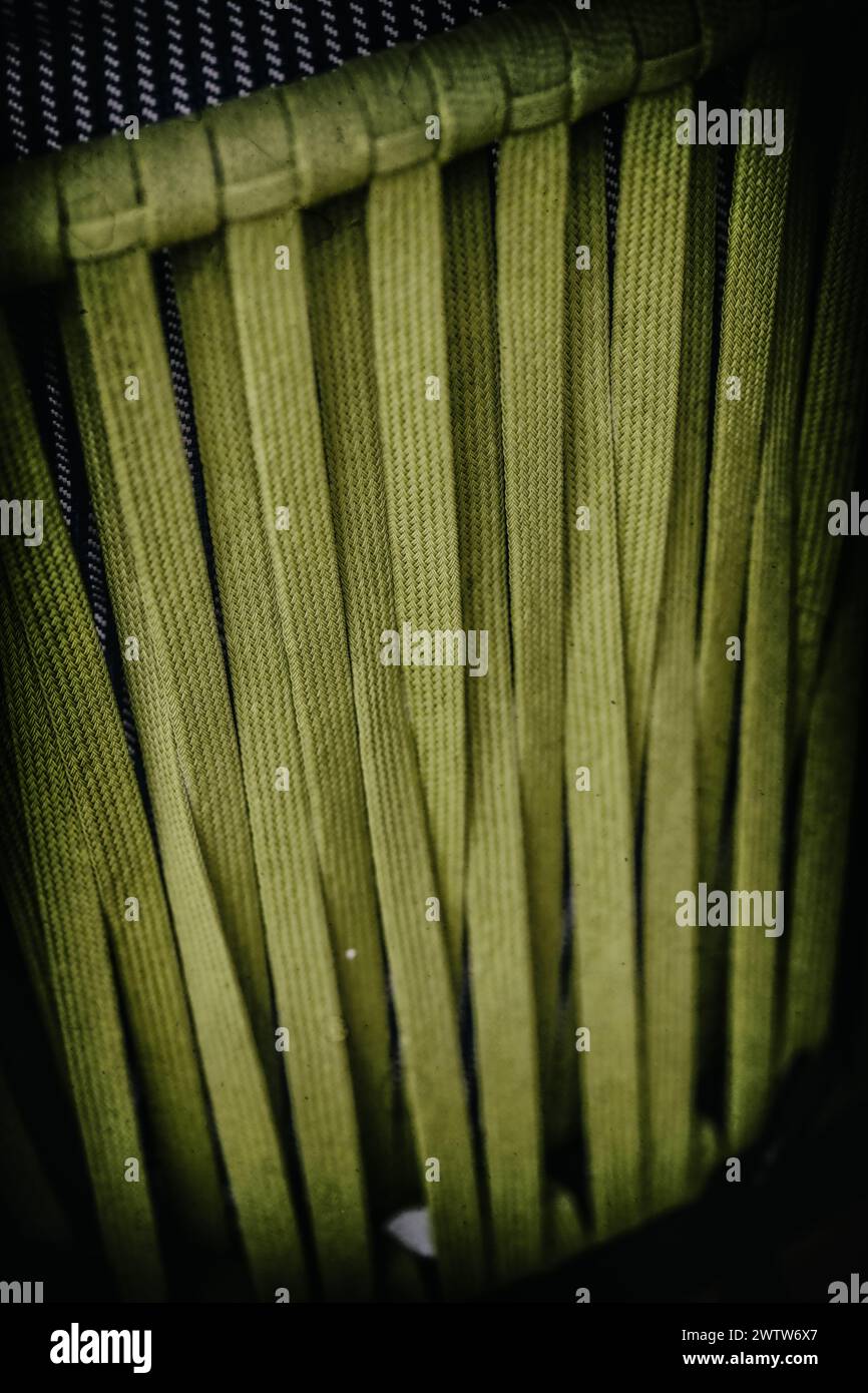 An up-close examination of the weave and texture of a green chair, highlighting intricate craftsmanship and design Stock Photo