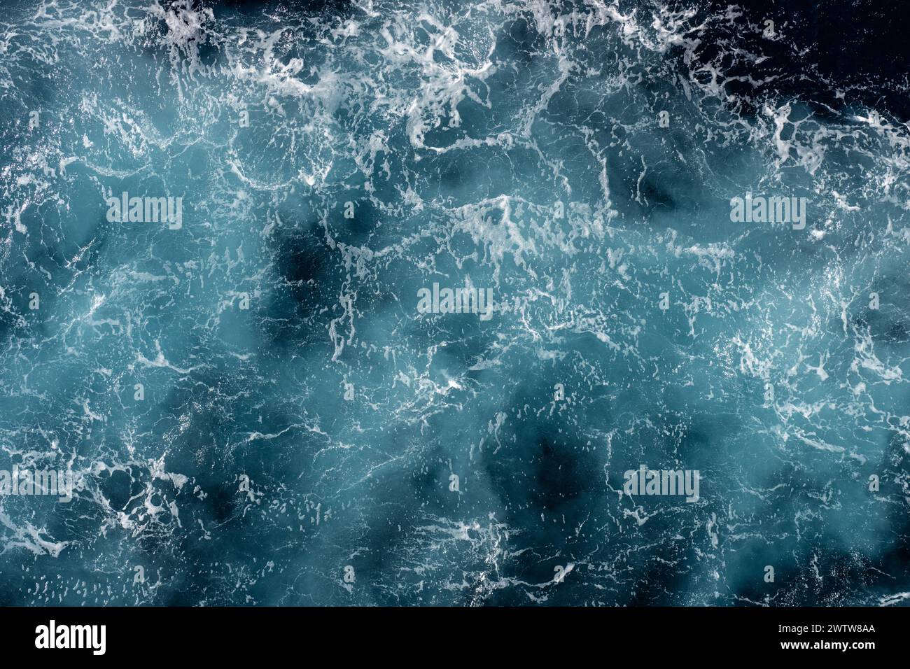 Aerial view of the tumultuous ocean with waves creating intricate
