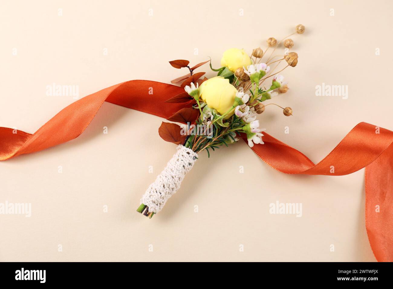 Stylish boutonniere and ribbon on beige background, top view Stock Photo