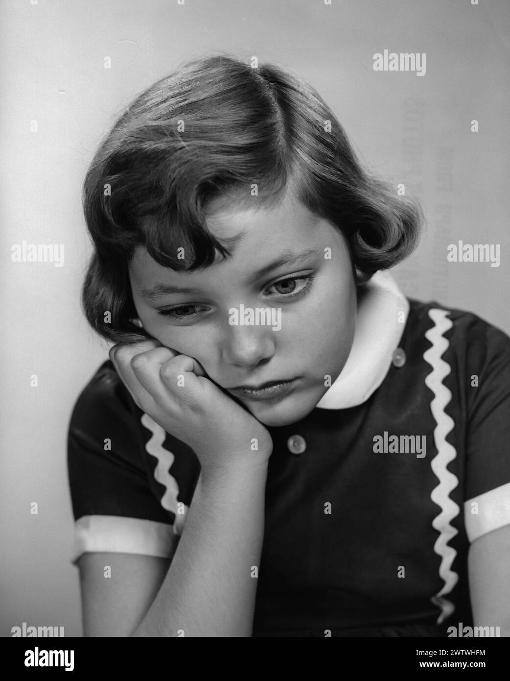 Young despondent girl with chin in hand glancing down Circa 1965 Stock ...