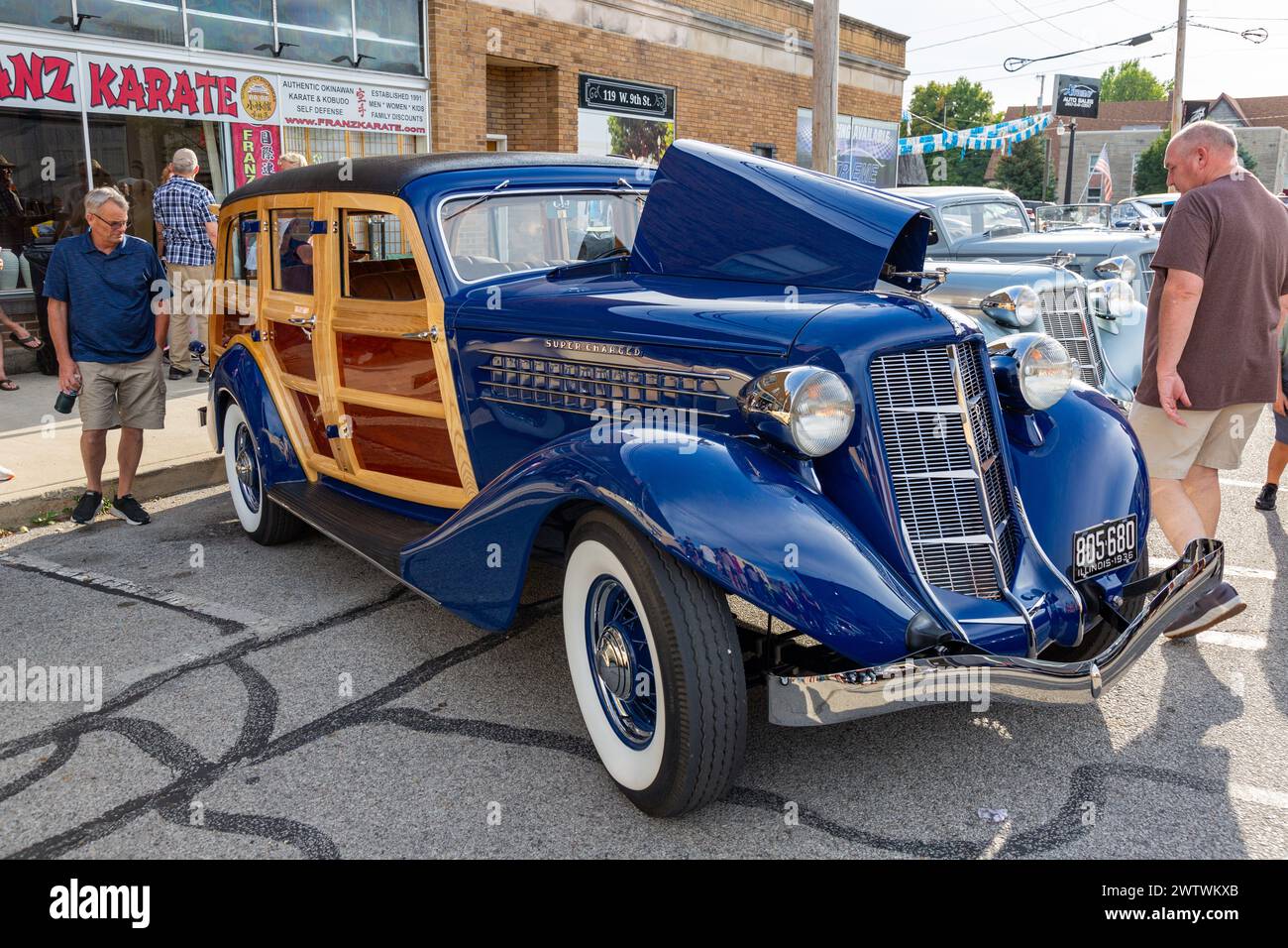 Two men admire a customized blue 1936 Auburn 852 Supercharged woody station wagon on display in Auburn, Indiana, USA. Stock Photo