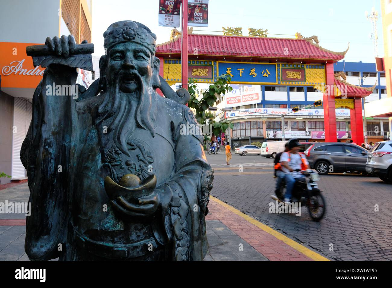 The statue of God of Wealth with a Chinese arched gate in the background in Santo Domingo Chinatown.Santo Domingo.Dominican Republic Stock Photo