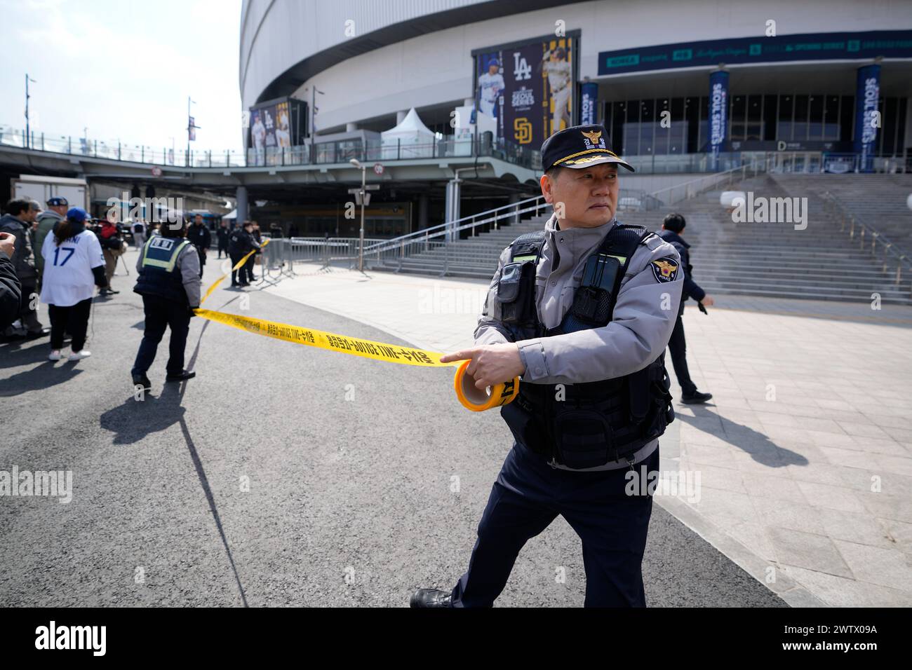 Police officers put police line near an unattended bag, unseen, outside ...