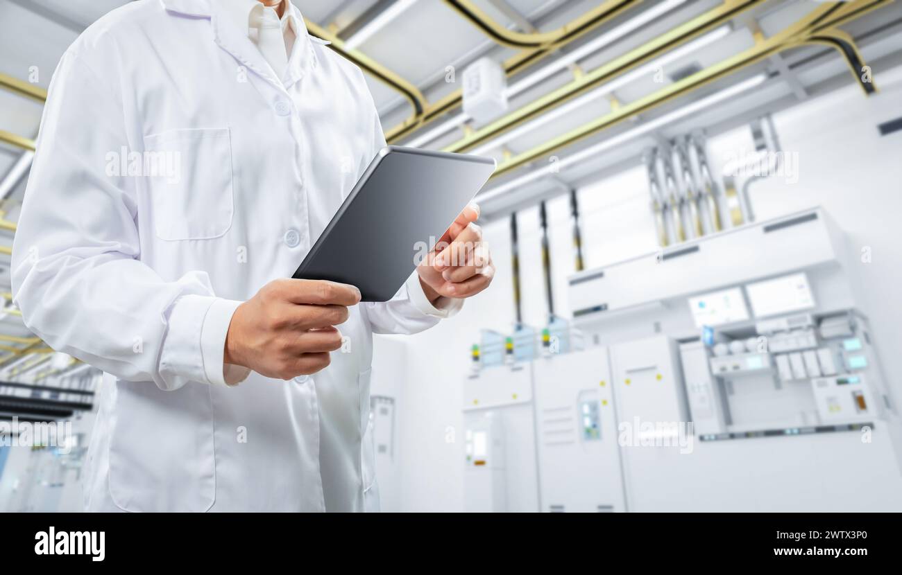 Worker or engineer wears lab coat work in semiconductor manufacturing factory Stock Photo