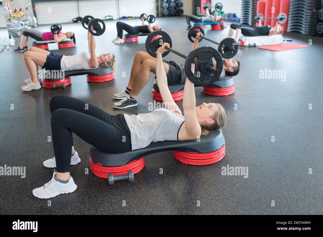 group of people exercising with barbell bars in gym Stock Photo