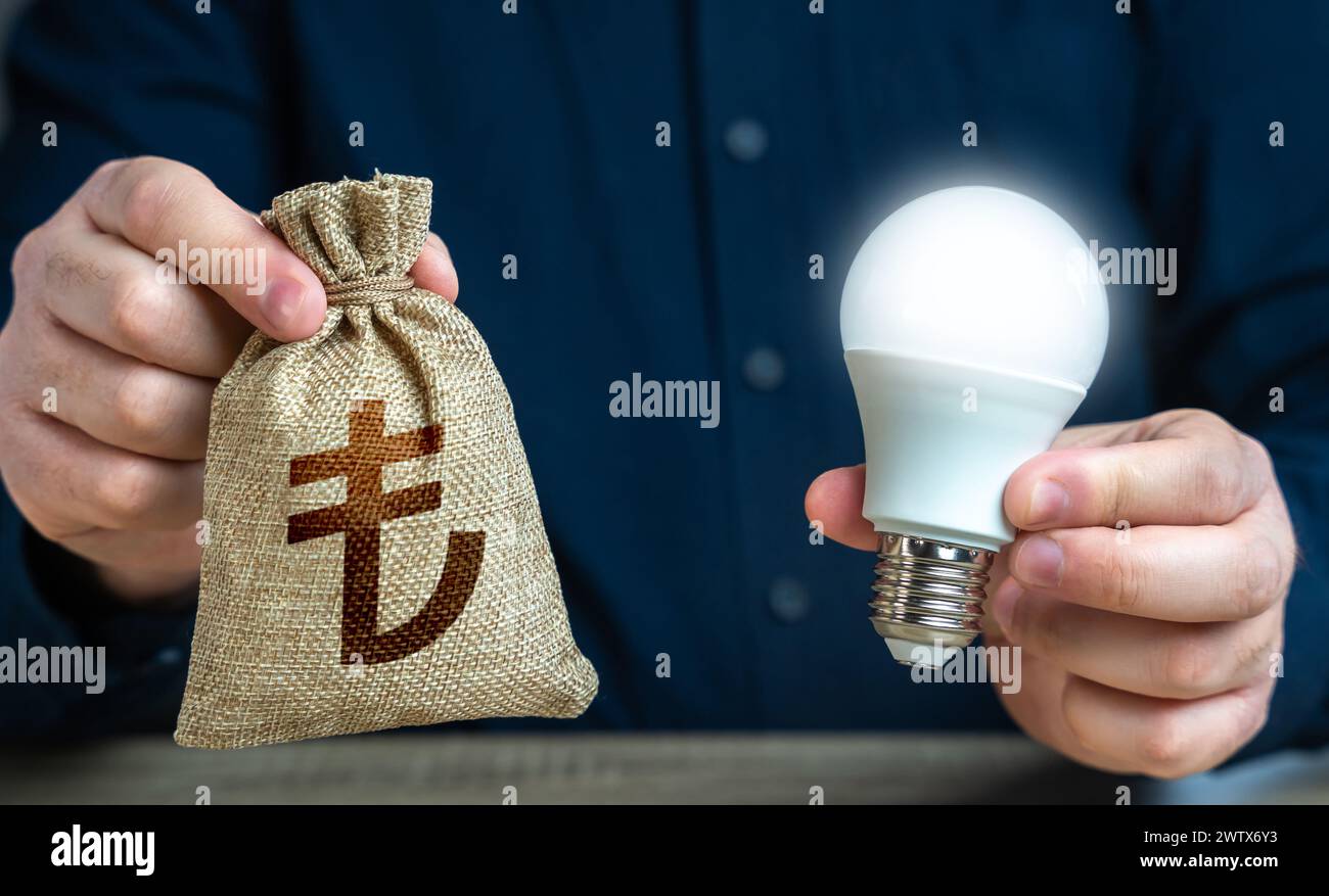 Turkish lira money bag and burning idea light bulb in the hands of a man. Reduce carbon footprint. Investment in an idea. Offering financial incentive Stock Photo