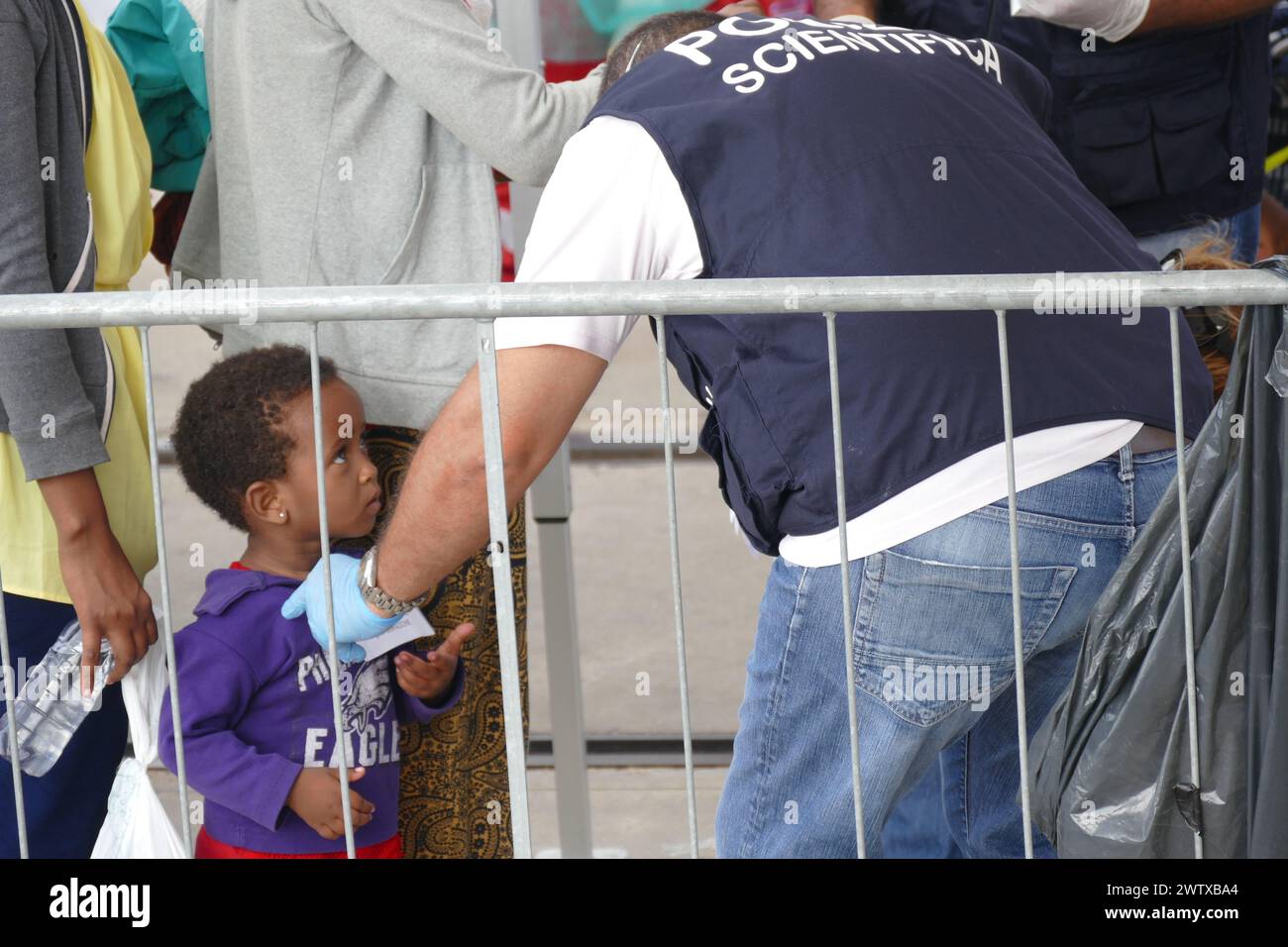 An unaccompanied child is greeted by Sicilian authorities after being rescued by a humanitarian ship in the Mediterranean on 12th July, 2016. Stock Photo