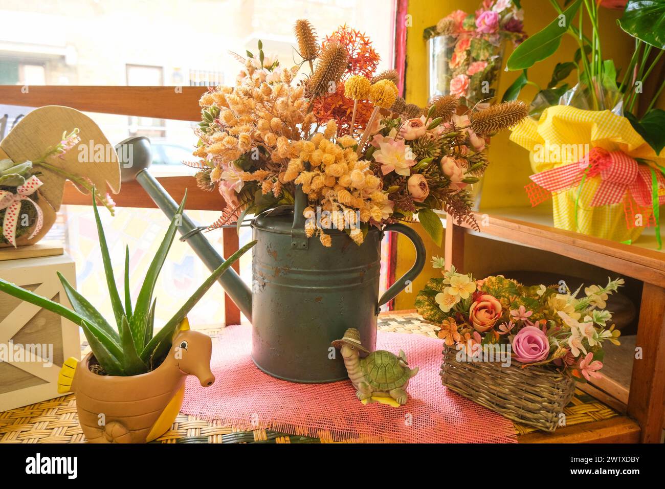 bouquet of dry flowers in pastel colors in an old blue iron watering ...