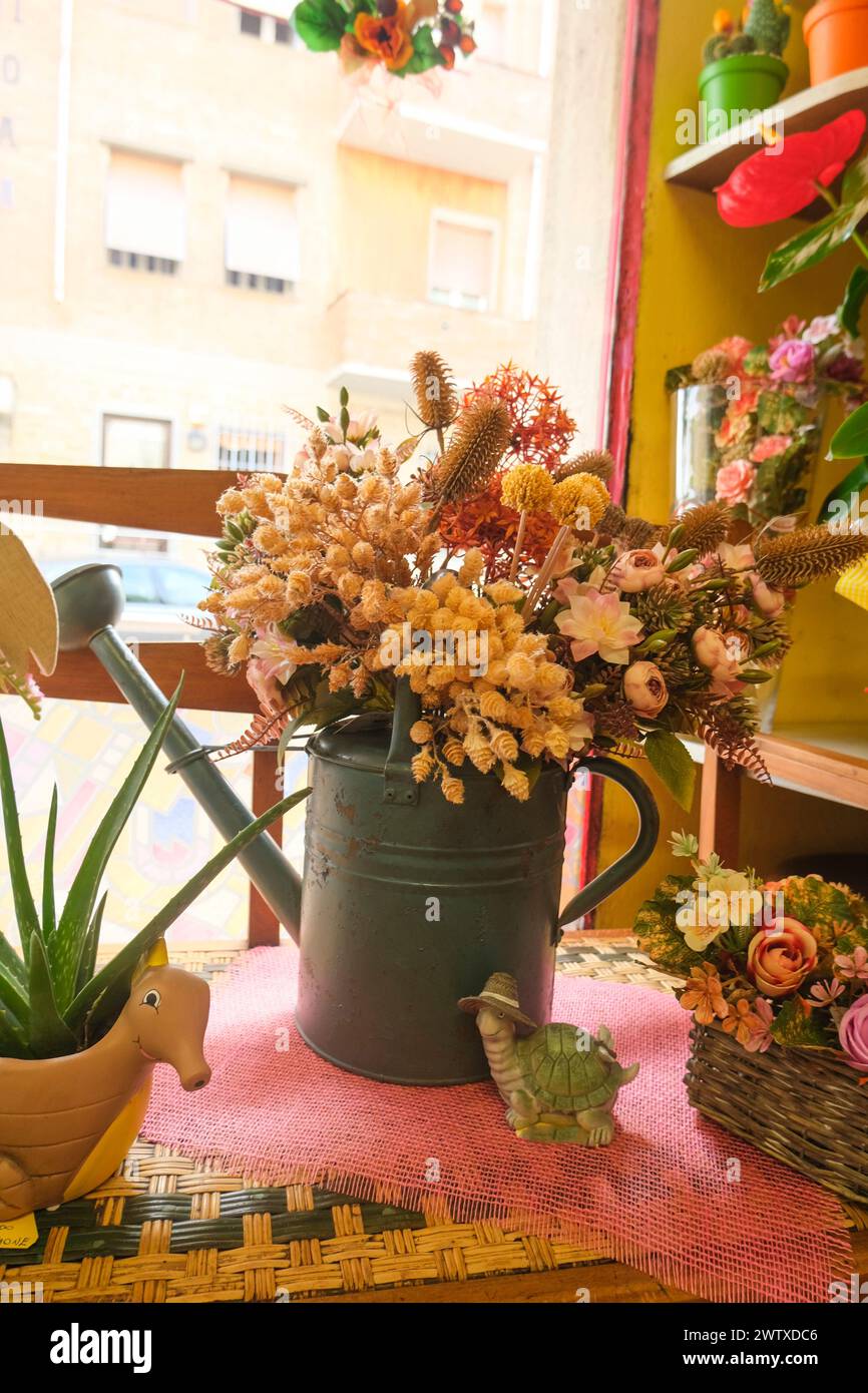 bouquet of dry flowers in pastel colors in an old blue iron watering ...