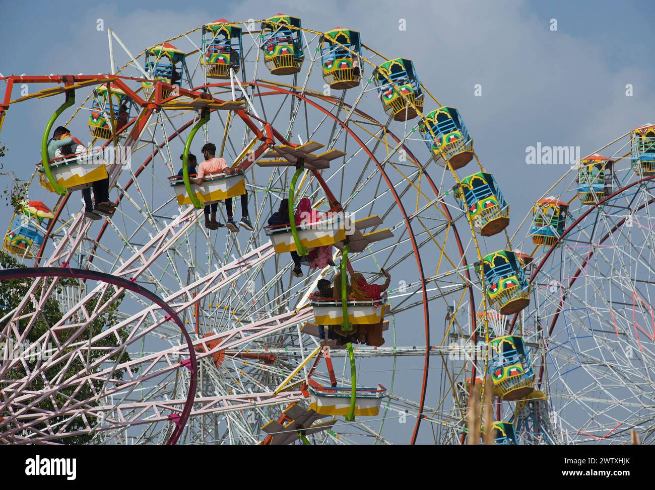 Young Indians couples enjoying a ride on ferris wheel in the ground of the desert town of Pushkar, Rajasthan, India, Asia Stock Photo