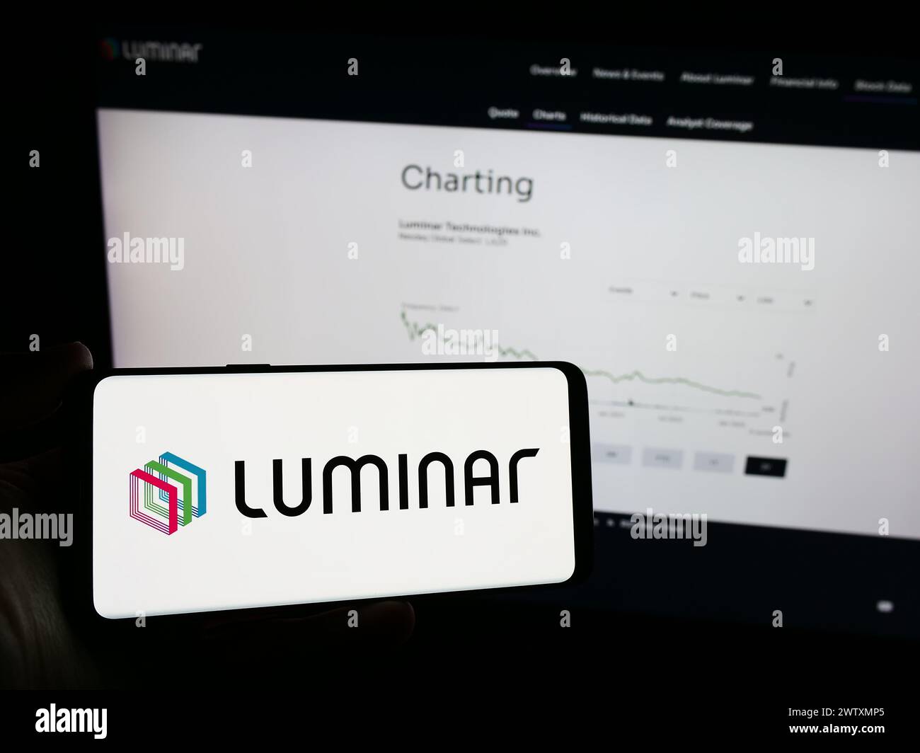 Person holding mobile phone with logo of American lidar technology company Luminar Technologies Inc. in front of web page. Focus on phone display. Stock Photo