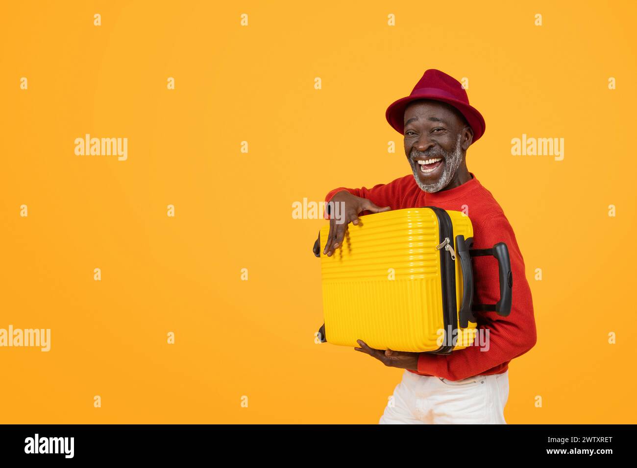 Cheerful senior black man wearing a red hat and sweater, holding a ...